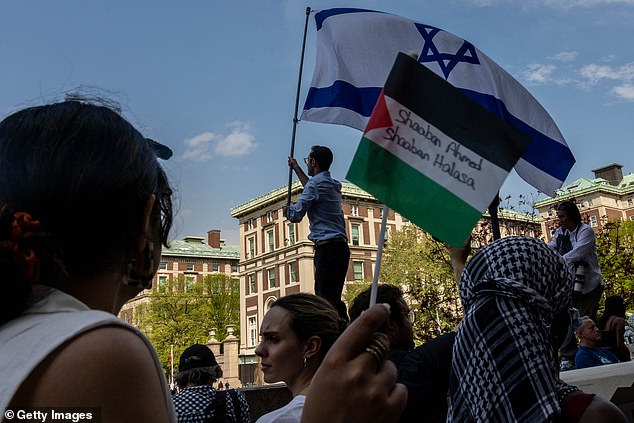 A protester waves the Israeli flag at the encampment established in support of Palestinians in Gaza