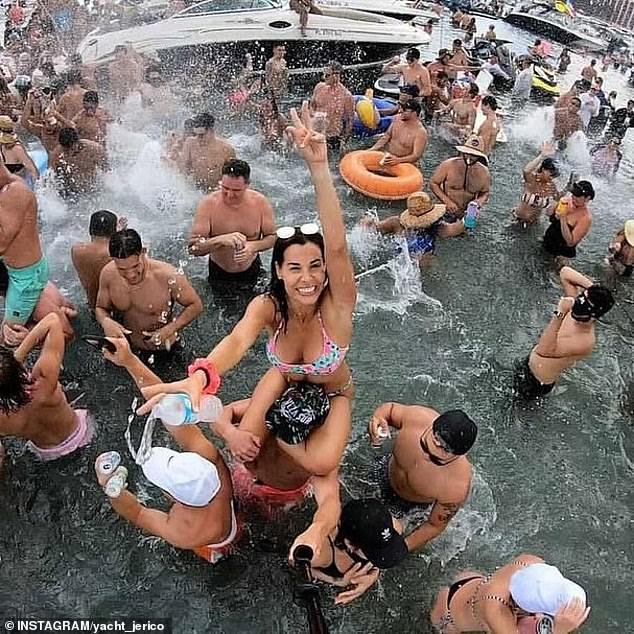 A woman in a bikini was seen on a man's shoulders as she posed for the camera as a water bottle was thrown from her hand