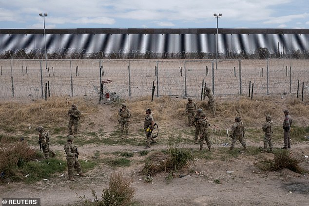 Construction of the border wall began in March under the Texas Facilities Commission.  This is the first section of border wall to be built in Zapata County, which has a population of just 14,000 (photo: A drone view shows the US in the background as members of the Army National Guard and Texas State Troopers patrol the bank of the Rio Grande River)
