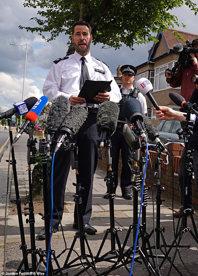 Chief Inspector Stuart Bell reads a statement to the media near the crime scene in Hainault, North East London, after a child died