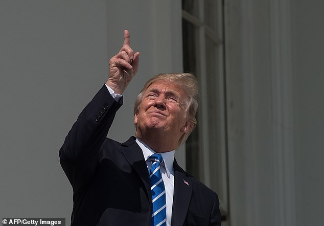 Then-President Donald Trump looks up at the partial solar eclipse from the White House balcony on August 21, 2017