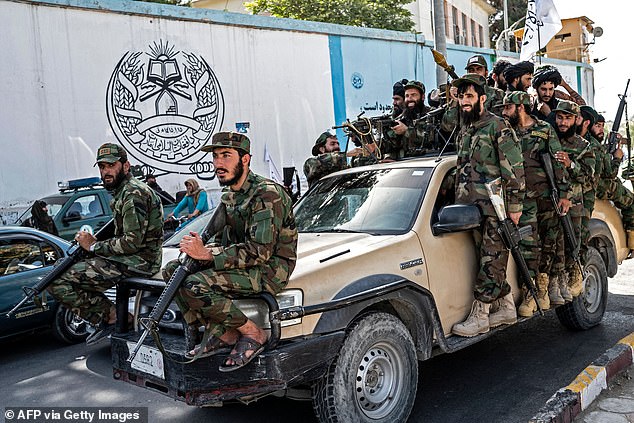 Armed Taliban security personnel ride in a vehicle convoy as they parade past the US Embassy in Kabul on August 15, 2023, during the second anniversary of their takeover