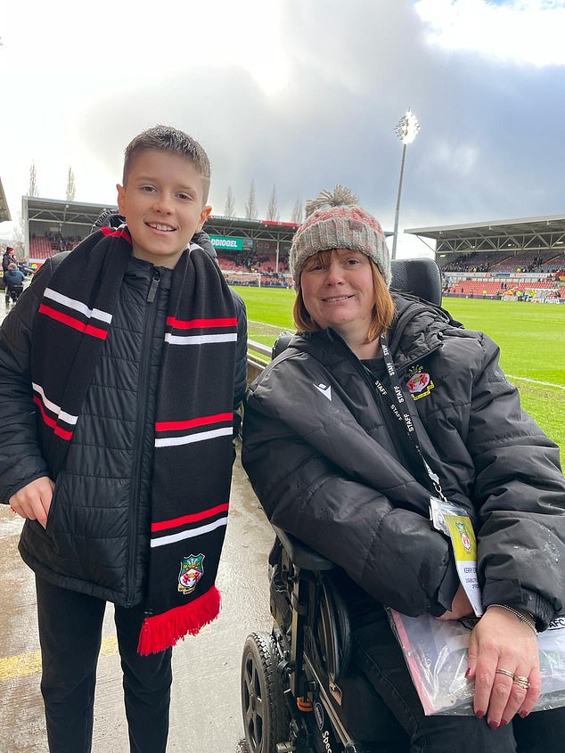 Wrexham fan Theo Smith, 10, poses with Kerry Evans, right, who has set up a 120-seat section at the Racecourse Ground for fans with autism and physical challenges to watch football