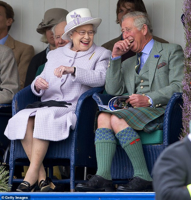 Then-Prince Charles, now King, and his mother, the late Queen Elizabeth, laugh while watching a children's sack race in Scotland in 2012