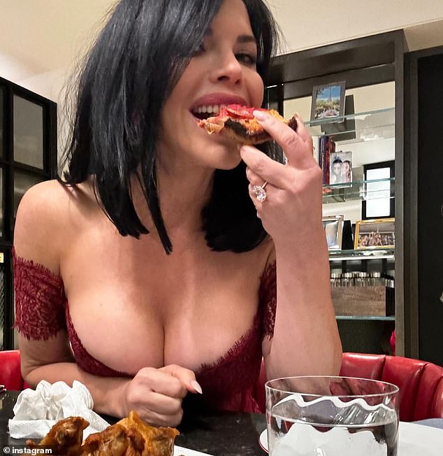 She also posted a photo from the end of the evening, enjoying a slice of pizza;  As she leaned towards the camera, her busty chest almost bulged out of her daring dress