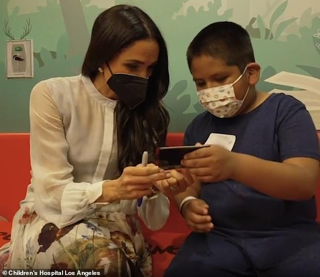 The Duchess of Sussex, 42, smiled warmly as she chatted to young patients and explained how the retro camera printing process works - when she made an appearance on March 21