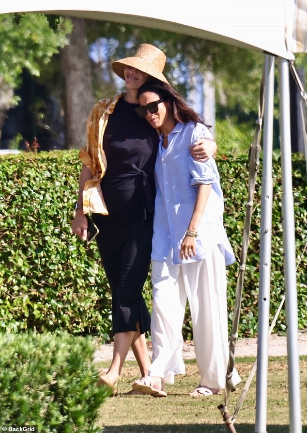 Meghan Markle, seen here with a hat-clad woman believed to be Delfina Blaquier, traded her stilettos for $760 Hermes slippers and fluffy bedding one day after she was mocked for her impractical on-court attire at a charity polo match in Miami , Florida