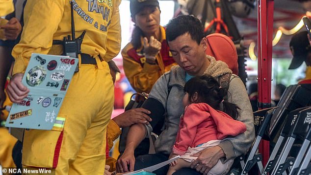 A man carrying a child receives medical attention at a temporary rescue command post after being rescued from Taroko National Park in Hualien on April 5.  Photo: I-Hwa Cheng / AFP