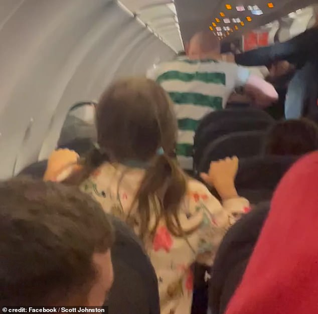 This is the moment a 'drunk' Celtic fan punched police officers during a shocking brawl on an easyJet flight 'after drinking a bottle of vodka'