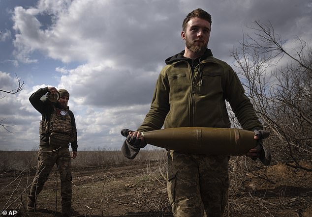 Ukrainian soldiers carry grenades to shell Russian frontline positions - now getting a billion-dollar injection in their efforts thanks to Congress