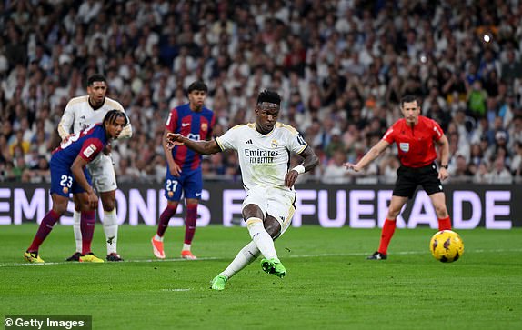 MADRID, SPAIN – APRIL 21: Vinicius Junior of Real Madrid scores his team's first goal from the penalty spot during the LaLiga EA Sports match between Real Madrid CF and FC Barcelona at Estadio Santiago Bernabeu on April 21, 2024 in Madrid, Spain.  (Photo by David Ramos/Getty Images)