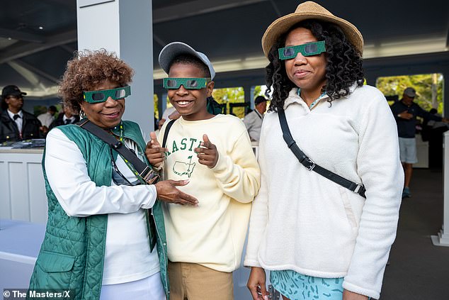 Masters fans are handed goggles in Augusta to view a historic total solar eclipse
