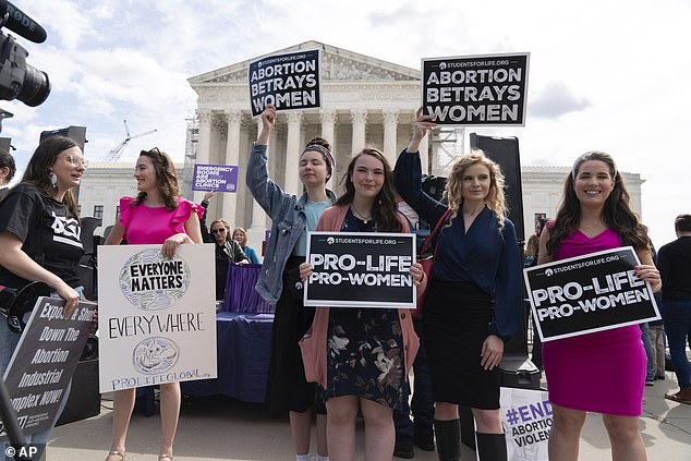 Anti-abortion activists gather outside the Supreme Court as the justices hear a case over Idaho's abortion ban, with limited exceptions