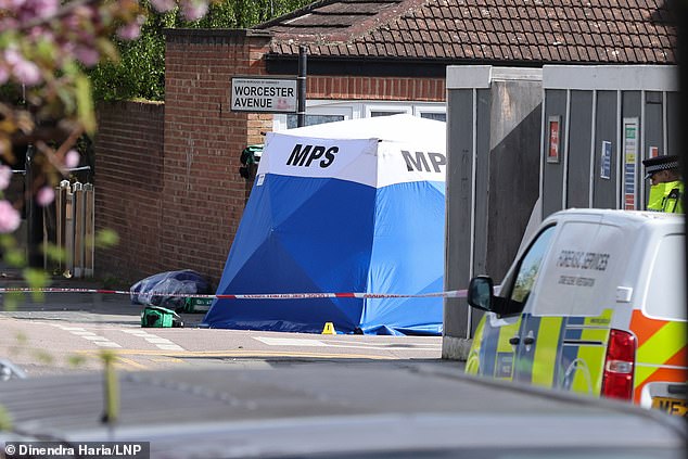 Forensic officers at a crime scene at the junction of Worcester Road and Northumberland Park, behind the Tottenham Stadium in north London today