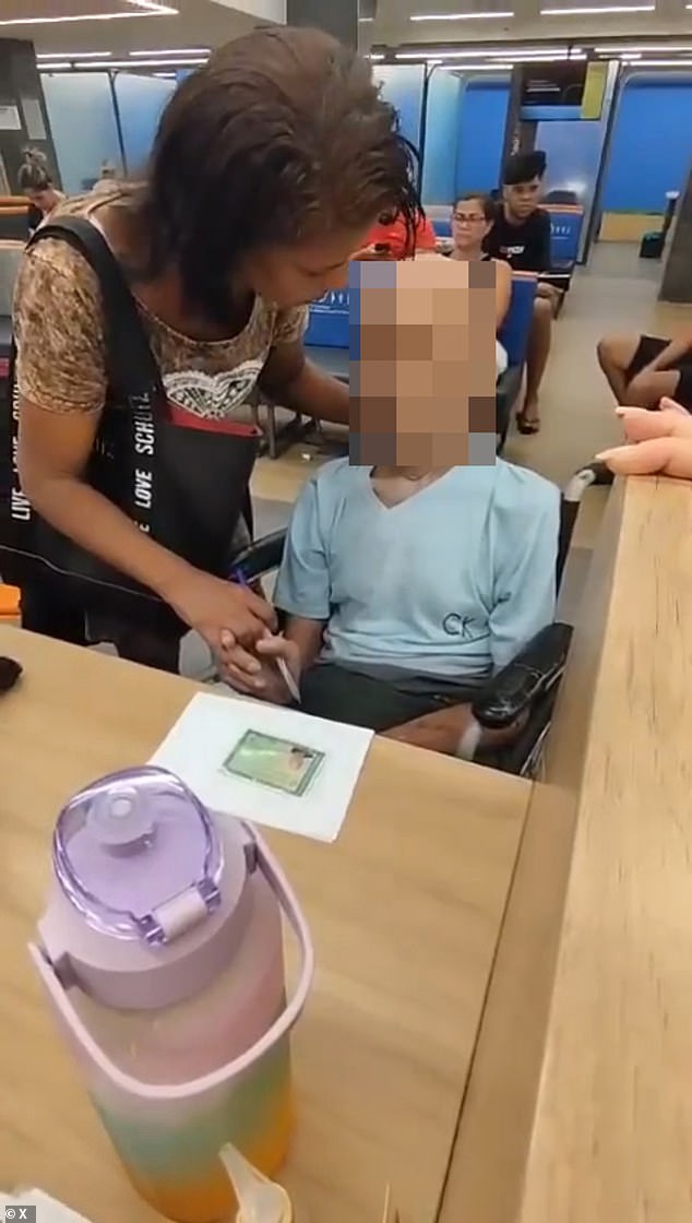 Bank employees began filming the pair and eventually called an ambulance and the police as she used her hand to hold the deceased pensioner's head up and said to him: 'Uncle, are you listening?  You have to sign it.  I can't draw for you