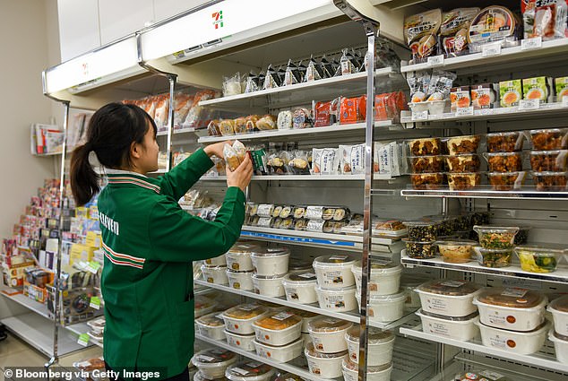 A worker replenishes rice balls at a 7-Eleven supermarket in Tokyo, Japan - the head of the brand's Australian operations said it has a lot to learn from Japan's 7-Elevens