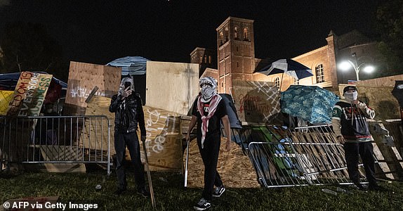 Pro-Palestinian protesters regroup and rebuild the barricade around the encampment set up on the University of California Los Angeles (UCLA) campus when clashes broke out with counter-protesters in Los Angeles on May 1, 2024.  Clashes broke out on May 1, 2024.  In 2024, US television media footage showed around pro-Palestinian demonstrations at the University of California, Los Angeles, as universities across the United States struggle to contain similar protests on dozens of campuses.  (Photo by ETIENNE LAURENT / AFP) (Photo by ETIENNE LAURENT/AFP via Getty Images)