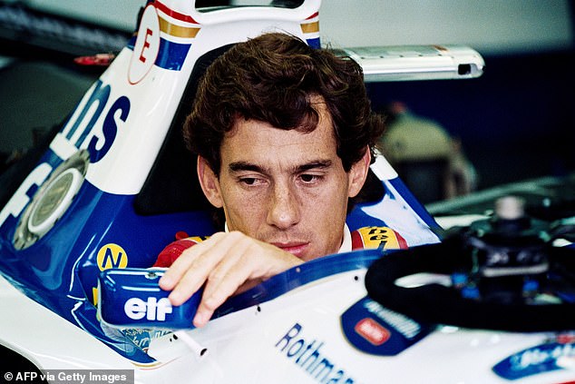 Senna adjusts his rear-view mirror in the pits before the 1994 San Marino Grand Prix
