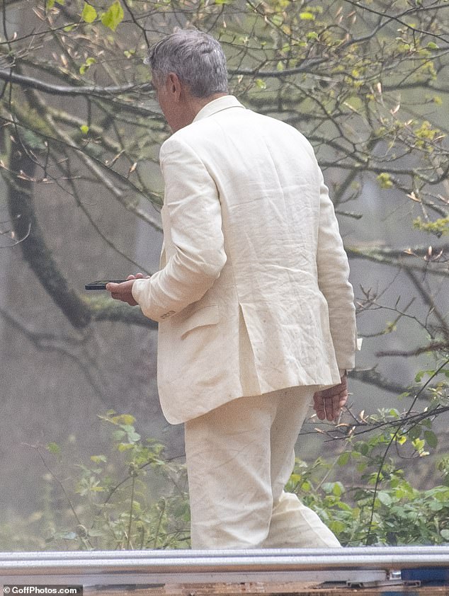 His chic ensemble was hardly appropriate for his outing as he looked sad as he ran through the trees with his mobile phone