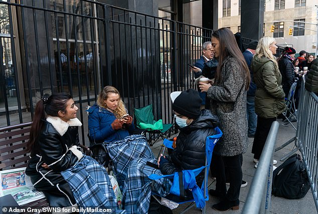 At the start of the trial, media wrapped themselves in blankets to protect themselves from the cold as they waited in line to take their seats in the courtroom