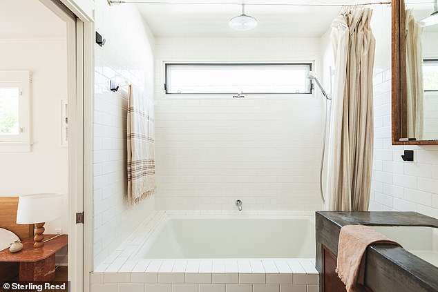 It is connected to a private bathroom with a custom sink and spa-style bath