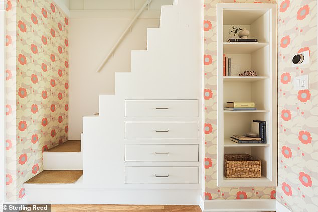 Via a wallpapered hallway with built-in storage space, the stairs lead to a renovated attic space