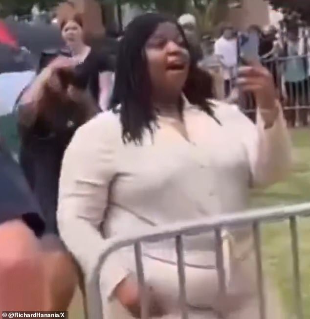 The protester stood her ground and filmed the baying crowd as they shouted profanities about her weight