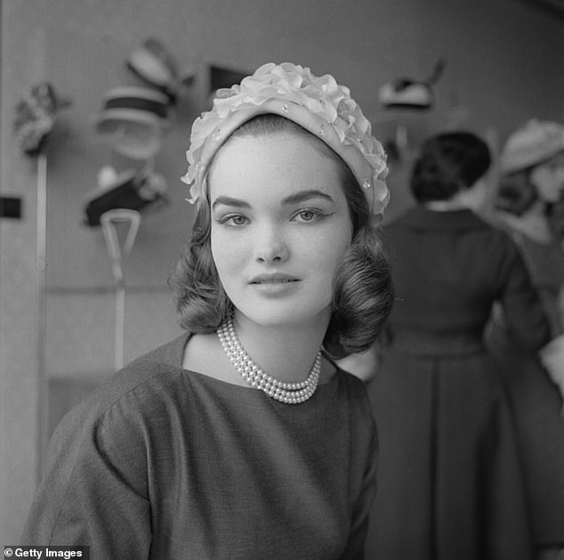 Henrietta Tiarks (later Henrietta Russell, Marchioness of Tavistock and Duchess of Bedford) modeling a hat in a hat shop in 1957