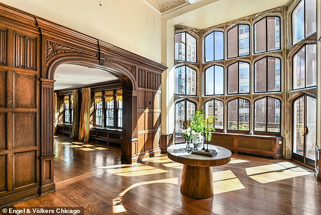 The home features a two-story living room with a fireplace and linen paneling