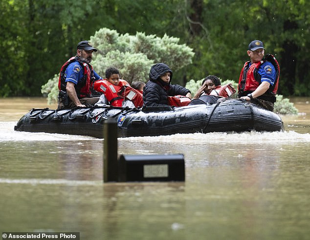 A woman responds as she and others are evacuated from their homes by boat by Montgomery County Sheriff's Office deputies