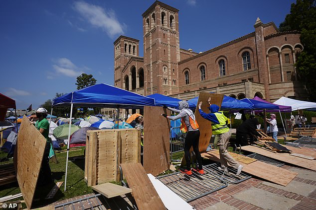 Protesters repair a protective barrier at an encampment on the UCLA campus on Wednesday