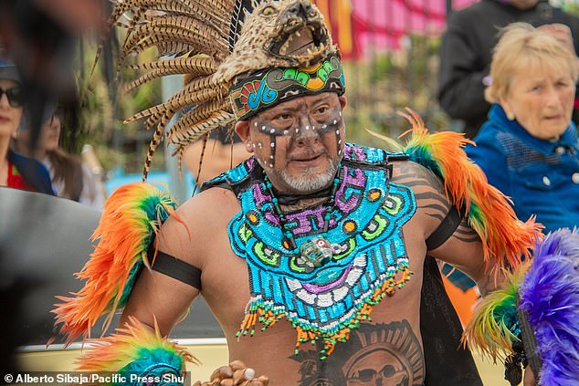 A man was seen wearing a feather headpiece as he danced around with bright body paint on his chest and jewelry