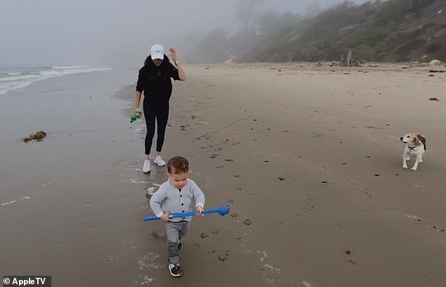 Archie walks along the beach with his mother and their beagle, Guy