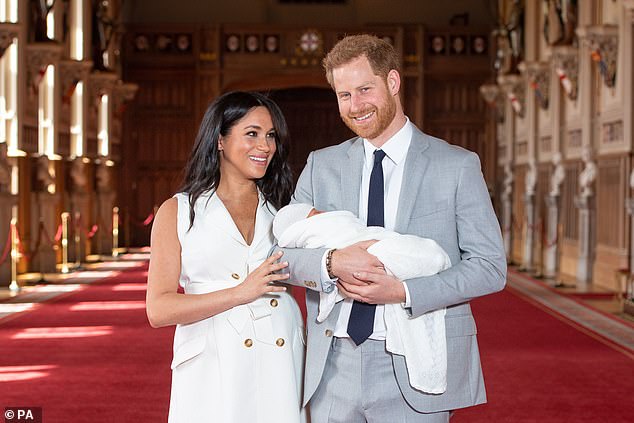 Meghan and Harry beam as they show off their newborn son to the world at St George's Hall at Windsor Castle