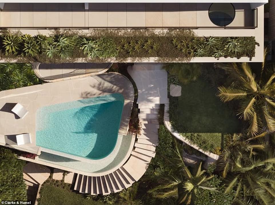 Outside, the leafy plot runs along the cliff side.  The organic pool mimics the contours of the ocean and a spiral staircase leads past the lush gardens to an open-air entertainment area