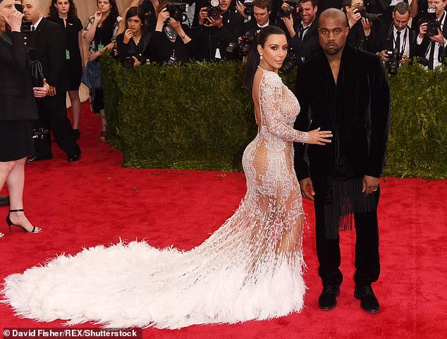 In 2015, Kim wore a beautiful semi-sheer white dress with a long, feathered white train, and Kanye wore an all-black suit