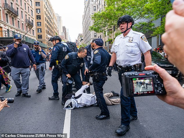 A protester is held in the street during demonstrations in New York