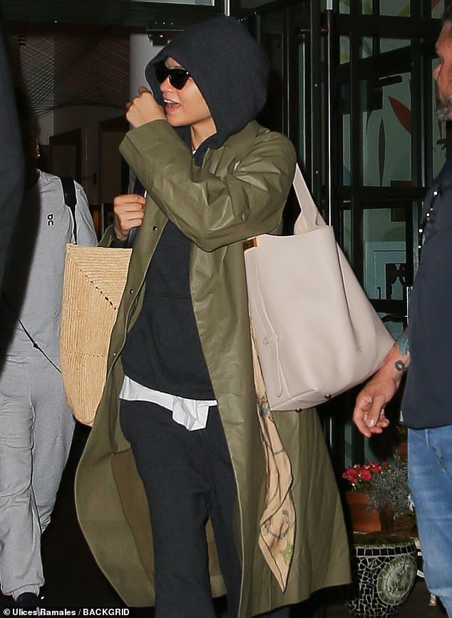 The star wore a dark gray hooded sweatshirt and matching sweatpants with a white button-up underneath