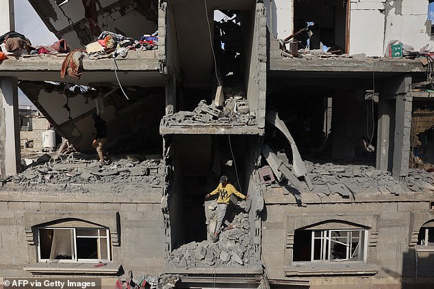 A Palestinian youth inspects damage in a destroyed building after the Israeli bombardment of Tal al-Sultan district in Rafah in the southern Gaza Strip on May 7, 2024