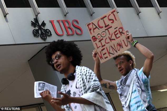 Protesters walk next to the UBS building as Columbia University students protest outside the University Trustees offices