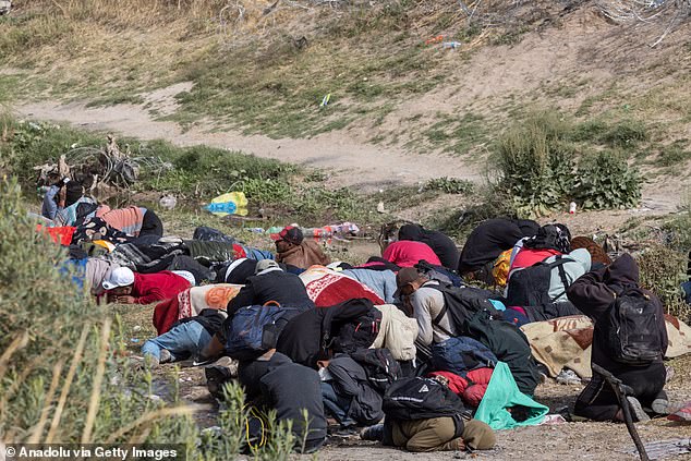 The Texas National Guard conducts an operation using non-lethal weapons, specifically a pepper spray gun, to disperse migrants maintaining a camp in the Rio Grande