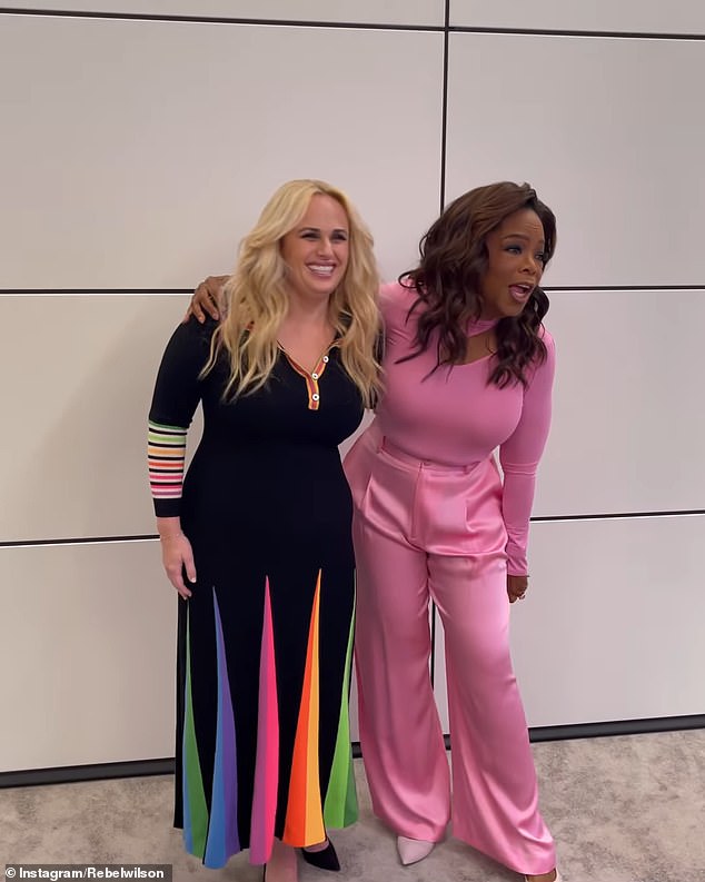 Rebel stunned in a fitted maxi dress that emphasized her figure and featured a rainbow embellishment.  Oprah, meanwhile, looked chic in a form-fitting pink top paired with candy-colored pants