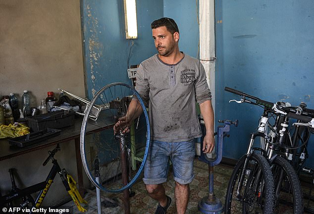 Asley Alfonso Gil works at his private bicycle repair business in Cienfuegos province, Cuba