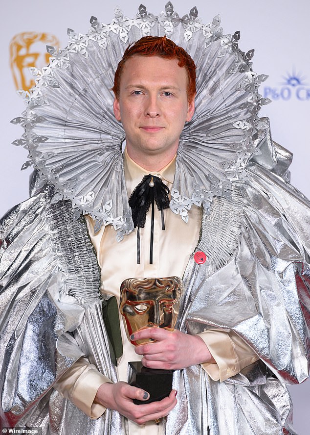 Joe Lycett poses with the Entertainment Performance Award for 'Late Night Lycett' with a red pin on his outfit