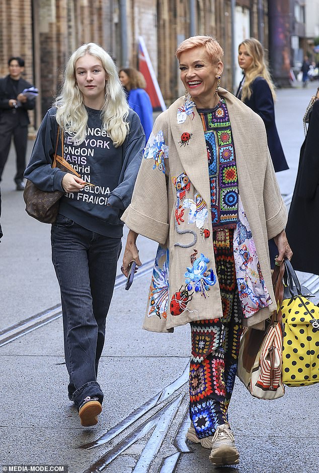 Doting mom Jessica (right) supported her daughter at the event, wearing a brightly colored doily-inspired knit top and matching pants, layered under a beige coat that was covered in animal-inspired embroidery