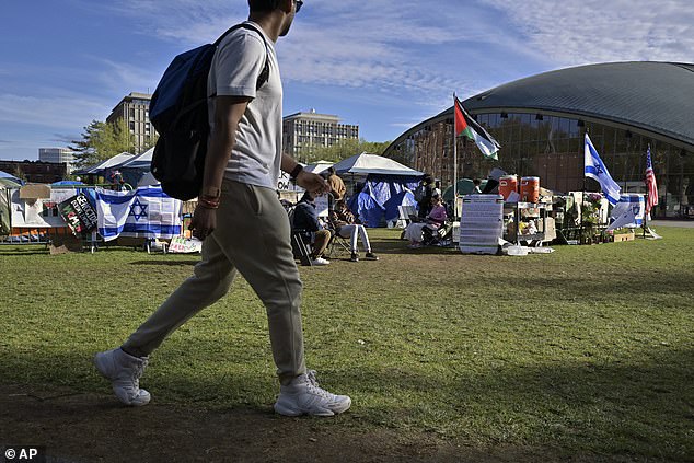 A student walks past demonstrations about the war in Gaza on the MIT campus in Cambridge, Massachusetts.  While young people across the country are protesting this issue, only 4 percent of six states said it was their top voting issue