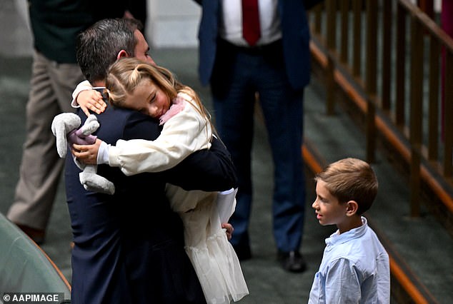 Australian Treasurer Jim Chalmers receives a hug from his daughter Annabel after delivering the 2024/25 budget statement, as his son Leo looks on