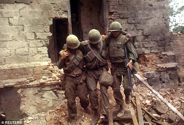 In this file photo, two U.S. Marines support a wounded soldier as they leave a building that was attacked on February 6, 1968 in South Vietnam