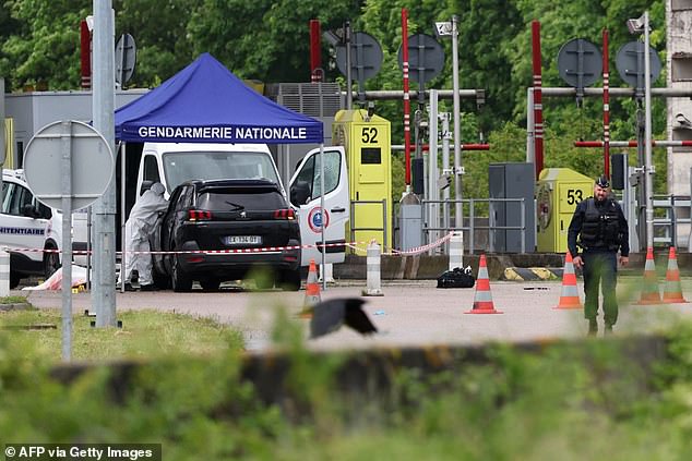 A forensic expert works at the scene of a late morning ram attack on a toll road in Incarville in the Eure region of northern France