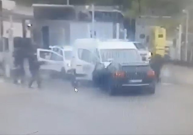 Several masked assailants are seen jumping out of the car armed with guns before opening fire on the van